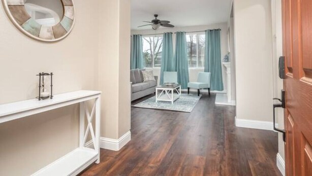A spacious living room with a white console table, a ceiling fan, a sofa, and a chair. - Fresno House - BBQ, Fire Pit, 3 Bed, 2 Bath & 2 Car Garage! (Fresno)