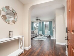 A spacious living room with a white console table, a ceiling fan, a sofa, and a chair. - Fresno House - BBQ, Fire Pit, 3 Bed, 2 Bath & 2 Car Garage! (Fresno)