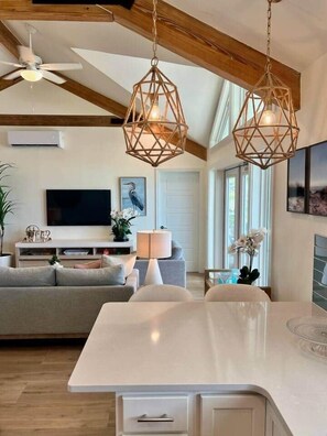 A modern kitchen with a central island, a ceiling fan, and pendant lighting.
