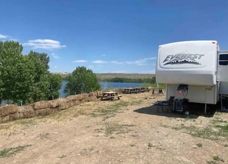 Outdoor dining. Lake shore queen bed trailer, tiki torches, & tent space for extra guest