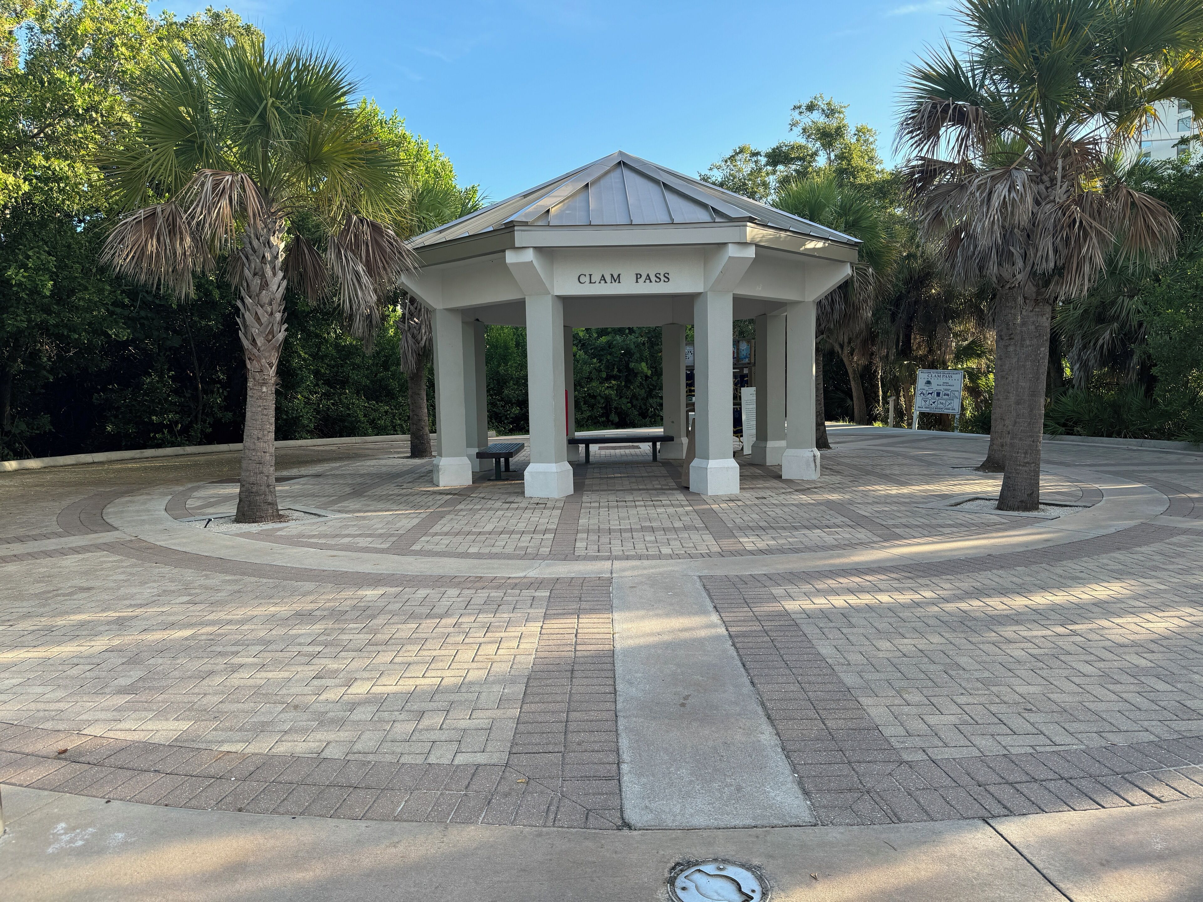 A gazebo named "CLAM PASS" with a tiled floor and benches.