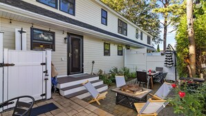 A residential house with a front porch, outdoor seating area, and a fire pit.