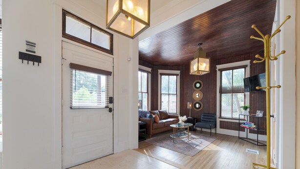 A spacious living area with a wooden ceiling, a sofa, a coffee table, and a television.