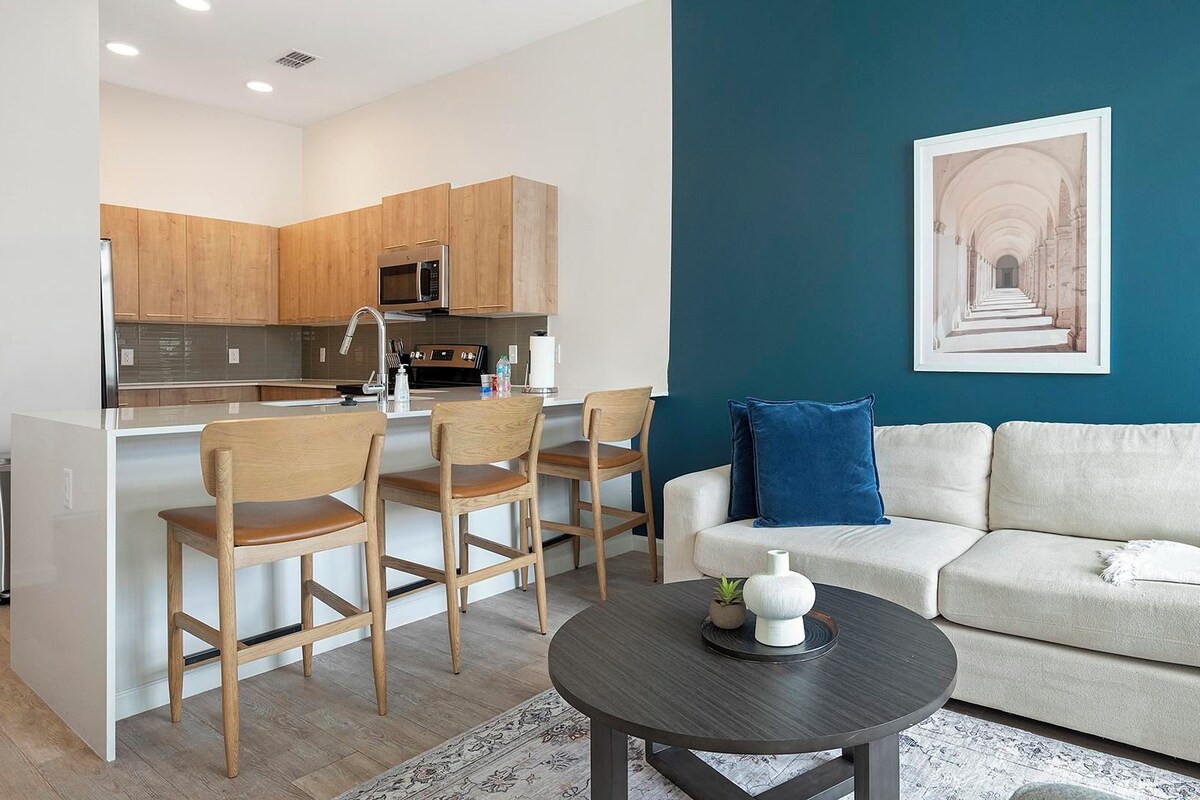 A modern apartment with a kitchen, dining area, and living room.