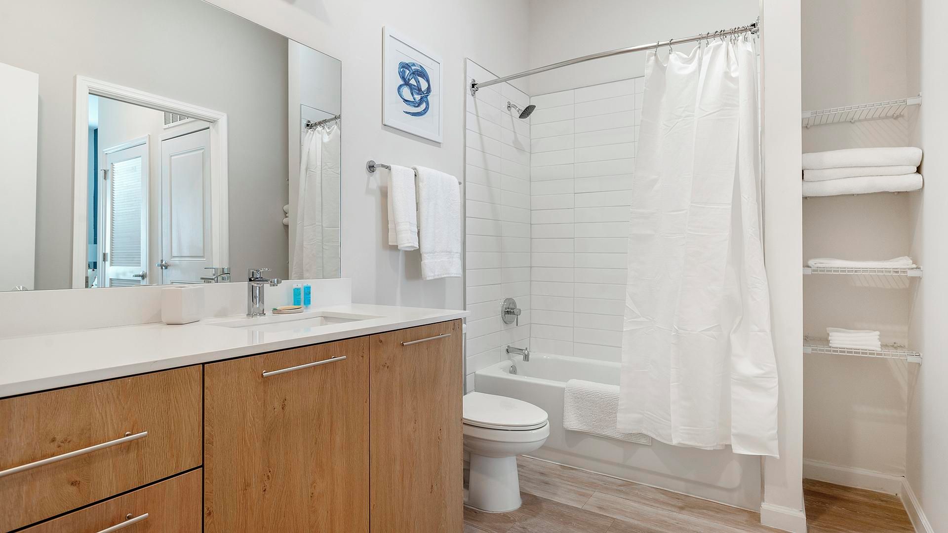 Une salle de bain moderne avec un meuble-lavabo en bois, une baignoire, une douche et des toilettes.