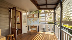 A wooden deck with a map on a stand, a wooden stool, and a door leading inside. - House of Fairy Wren - Fully renovated charming Queenslander! 10 Mins to BNE CBD! (Annerley)