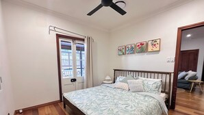 A bedroom with a bed, a ceiling fan, a window with curtains, and a door. - House of Fairy Wren - Fully renovated charming Queenslander! 10 Mins to BNE CBD! (Annerley)