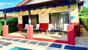 Ein überdachter Außenbereich mit Sitzgelegenheiten und einem Pool.