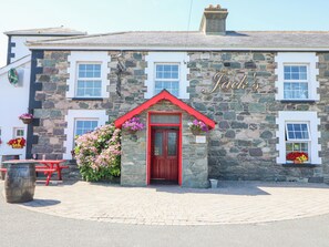 A stone building with a red door and the name "Jack's" on the facade.