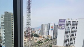 A cityscape with high-rise buildings, a prominent tower, and a billboard advertising a hotel. - Valdizán apartment in Av Brasil  (Jesús María)