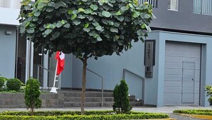 A modern building with a tree in front, a flag, and a sign with the number 121. - Valdizán apartment in Av Brasil  (Jesús María)