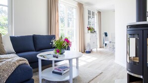 Un salon moderne avec un canapé, une table basse ronde et une cheminée.