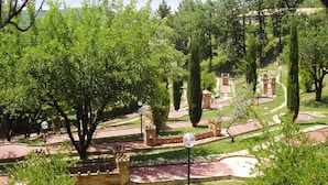 Un jardín ajardinado con senderos, una fuente y varias torres pequeñas.