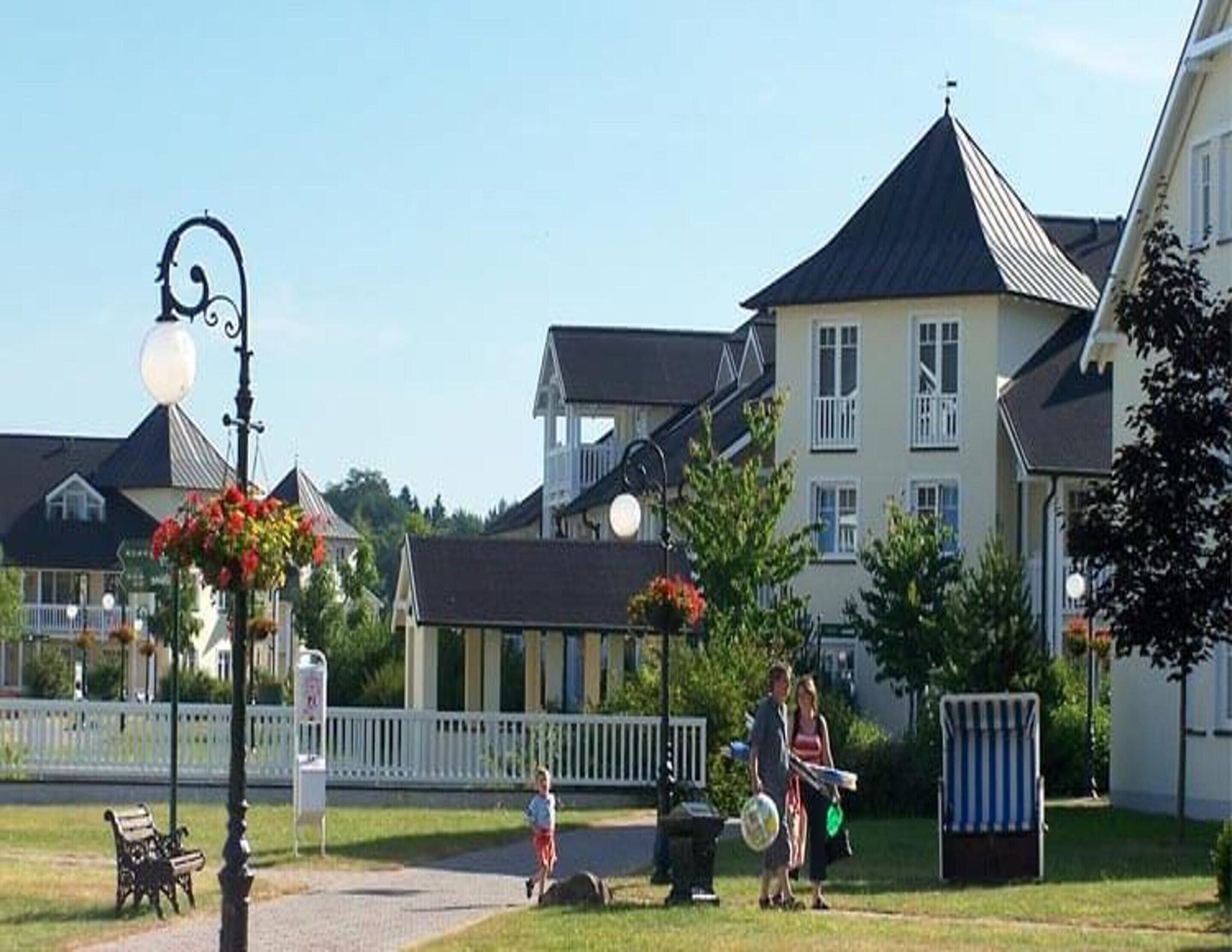 Een woonwijk met huizen, een lantaarnpaal en een bank.