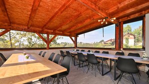 A conference room with a long table and chairs, large windows, and a wooden ceiling. - 2 bedroom nice home in Vinica Breg (Vinica Breg)