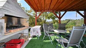 An outdoor patio with a barbecue grill, seating area, and a view of a vineyard. - 2 bedroom nice home in Vinica Breg (Vinica Breg)