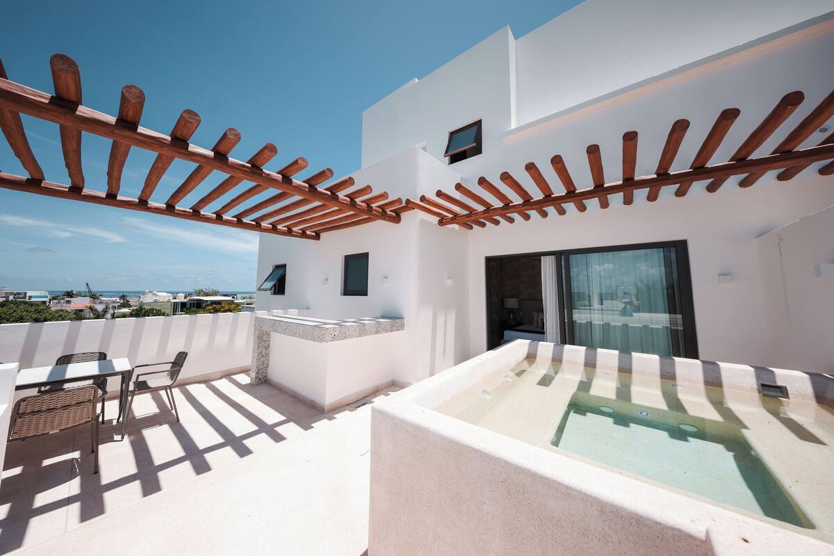 A rooftop terrace with a pool, a pergola, and a seating area.