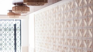 A corridor with patterned flooring, a decorative wall, and a door with a geometric design.