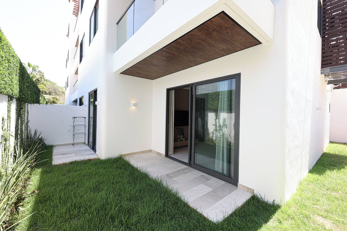 A modern two-story house with a flat roof, large sliding glass doors, and a small front porch.