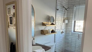 A modern bathroom with a toilet, sink, and shower.