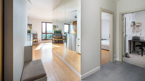 A modern interior with a dining area, kitchen, and a bedroom.