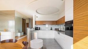 A modern kitchen with white cabinetry, wooden accents, and a central island.