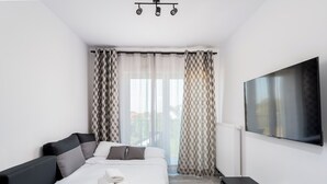 Ein modernes Hotelzimmer mit Bett, Fernseher und Schreibtisch.