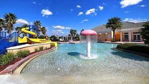 A water park with a large pool, a water slide, and palm trees.