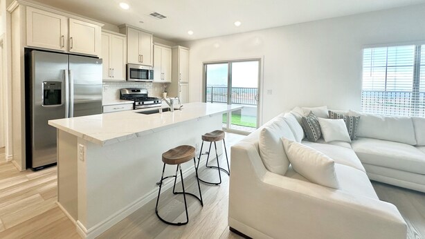A modern kitchen with a central island, stainless steel appliances, and a white countertop. - Luxurious Summerlin Townhome,BEDROOM downstairs/Loft UP with STRIP&CITY VIEWS!!! (Las Vegas)