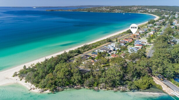 An aerial view of a coastal area with a beach, residential buildings, and a road. - Palms on Collingwood by Experience Jervis Bay (Vincentia)