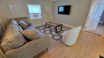 A living room with a sofa, a coffee table, and a TV.