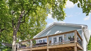 Une maison à deux étages avec une terrasse en bois et un garage.