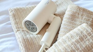A hair dryer on a textured beige blanket. - Fukuoka Loft 203  (Fukuoka)