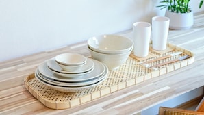 A neatly arranged dining set on a wooden tray with plates, bowls, and cups, accompanied by chopsticks, on a light-colored table. - Fukuoka Loft 203  (Fukuoka)