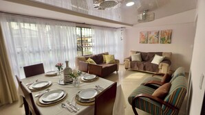 A dining area with a table set for four, a sofa, and a couch.
