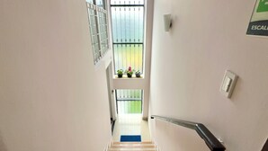 A staircase leading to a landing with a view of a balcony.