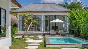 A modern house with a swimming pool, a thatched roof, and a well-maintained garden. - Beta Villa by Betterplace (Ubud)