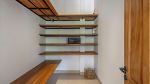 A hallway with wooden shelves, a bench, and a basket.