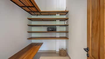 Un pasillo con estanterías de madera, un banco y una cesta.