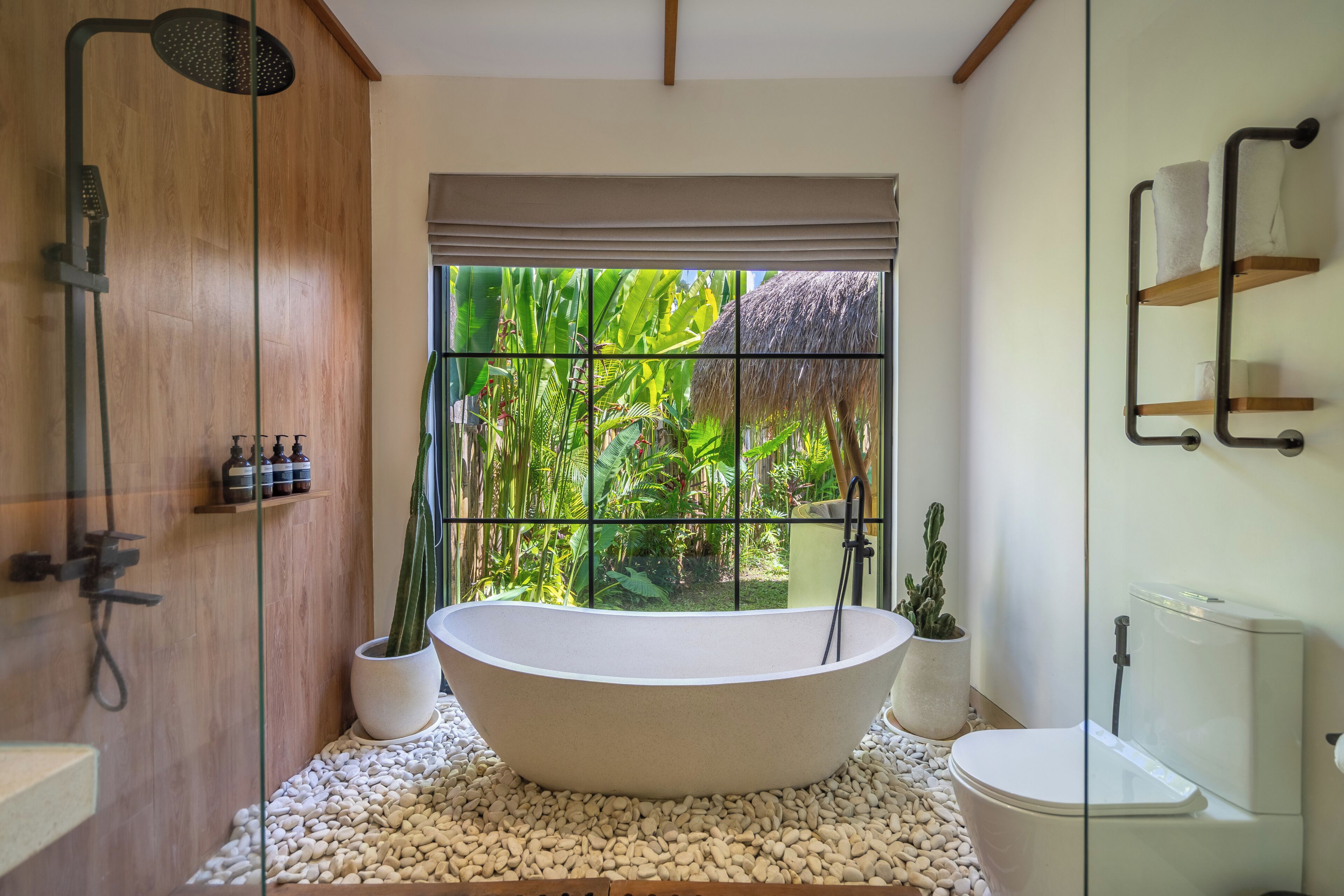 A bathroom with a freestanding bathtub, a toilet, and a shower area.