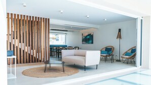 Een modern interieur met een bank, stoelen, een eethoek en een trap.