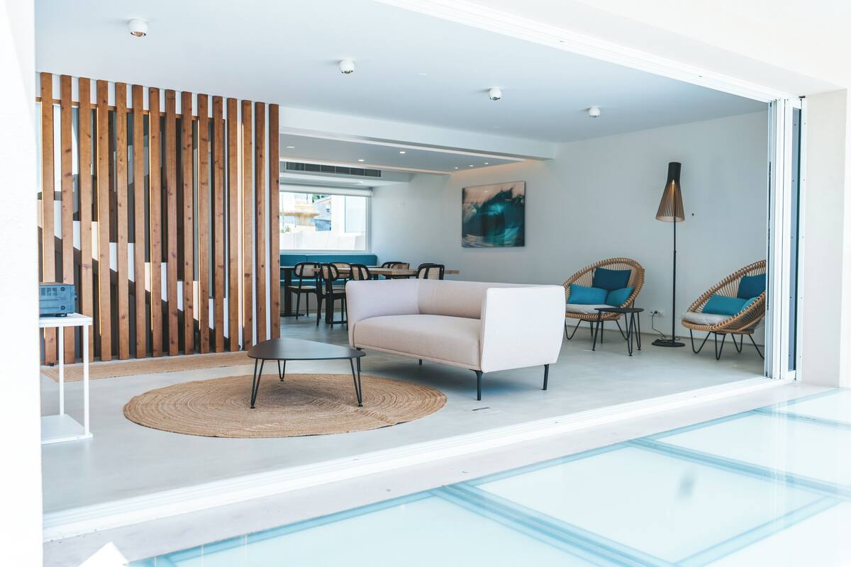 Een modern interieur met een bank, stoelen, een eethoek en een trap.