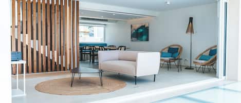 En modern inredning med en soffa, stolar, en matplats och en trappa.