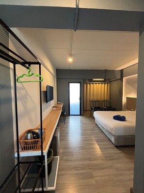 A hotel room with a bed, a desk, a chair, a TV, and a window. - Watkethotel (Chiang Mai)