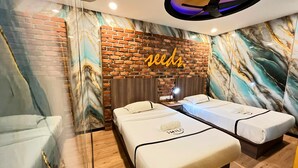 A hotel room with two beds, a brick accent wall, a ceiling fan, and a marble-patterned wall. - Seeds Hotel Cheras Maluri (Kuala Lumpur)