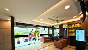 A hotel lobby with a reception desk, seating area, and a view of the street outside. - Seeds Hotel Cheras Maluri (Kuala Lumpur)