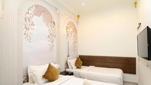 A hotel room with two beds, a wooden headboard, a television, and decorative wall art. - Seeds Hotel Shah Alam Seksyen 19 (Shah Alam)