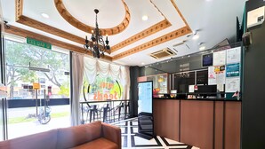 A hotel lobby with a reception desk, a sofa, a chandelier, and a view of the street outside. - Seeds Hotel Shah Alam Seksyen 19 (Shah Alam)