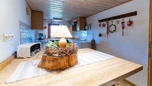 Eine Küche mit einem Holztisch, einer Lampe und einem Nest auf dem Tisch.