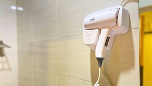 Ein an der Wand befestigter Föhn mit einer aufgewickelten Kabeltrommel.